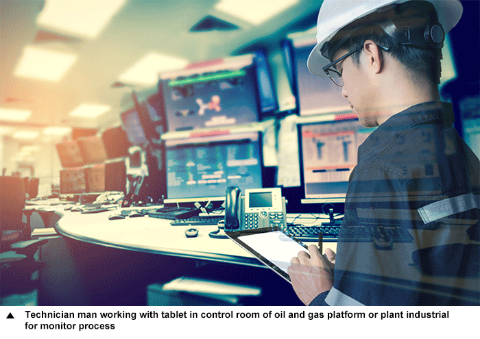Technician man working with tablet in control room of oil and gas platform or plant industrial for monitor process